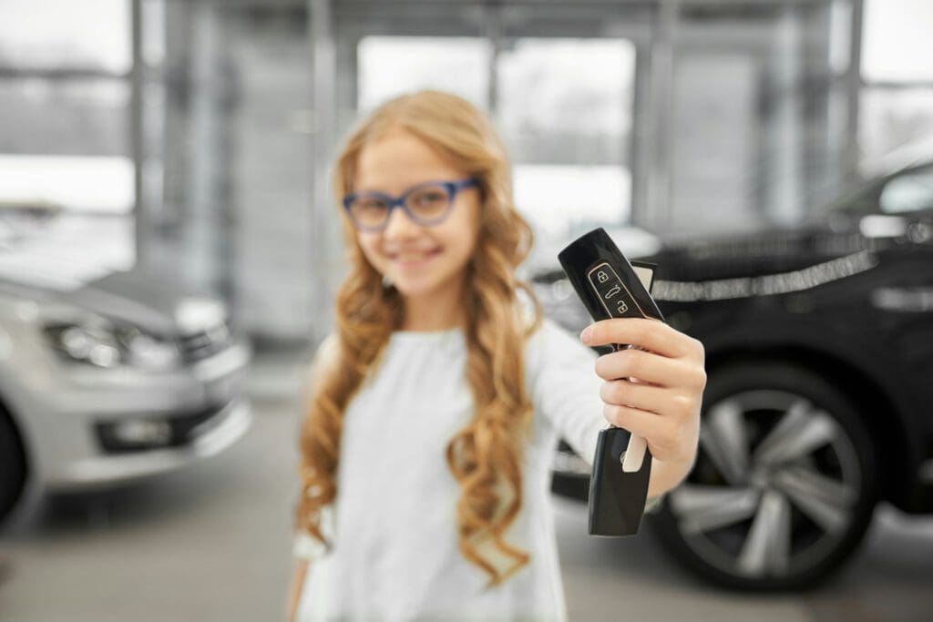 Car keys close up, child holding keys, posing